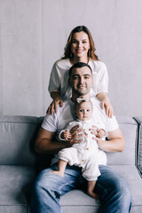 Obraz premium Young happy family mother, father, child daughter at home