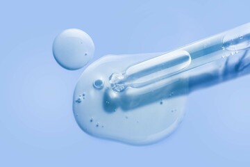 Liquid cool blue gel or serum on blue glass of microscop background