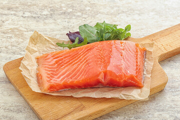 Raw salmon fillet over board