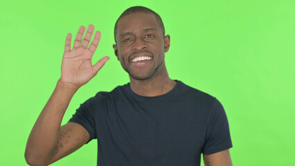 Young African Man Waving, Welcoming on Green Background