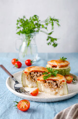 Zucchini stuffed with minced meat and rice, with tomatoes and mozzarella.