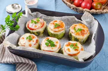 Zucchini stuffed with minced meat and rice, with tomatoes and mozzarella.