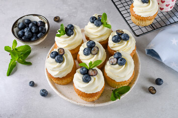 Vanilla cupcakes with blueberries and with cream cheese frosting