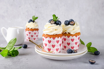Vanilla cupcakes with blueberries and with cream cheese frosting