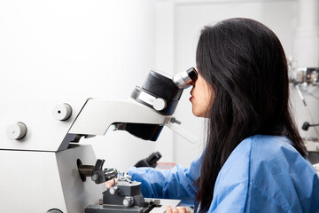 Fototapeta premium Young female scientist using an ultramicrotome to make sections for the electron microscope