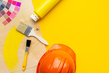 House renovation and painting background with construction helmet and brushes