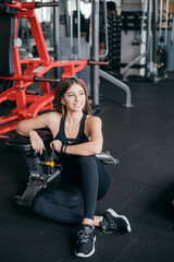 Fototapeta premium Pleasant woman in sportswear resting after training at gym