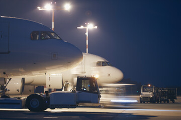 Busy airport at night. Preparation of airplanes before flight. .