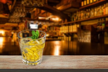 Glass of alcohol whiskey on the bar counter. Blurred interior of bar at the background.