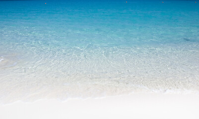 Soft wave of turquoise water on white sand beach