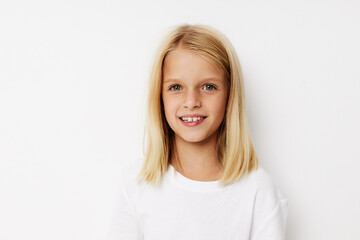 Beautiful little girl in a white t-shirt grimace posing studio