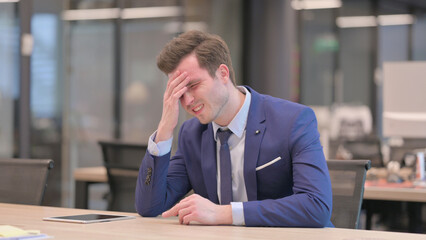 Sleepy Businessmanhaving Headache While Sitting in Office