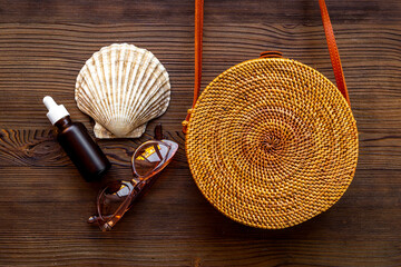 Summer beach background rattan bag with tanning oil and seashells