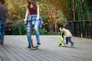 Asian woman enjoy playing and riding modern extreme stunt kick scooter without using any safety...