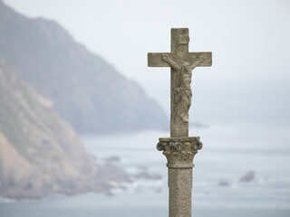 Stone cross with sea and cliffs in the background