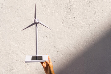 Crop anonymous person showing toy windmill on sunny day
