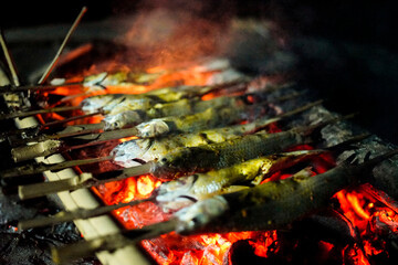 grilled fish stabbed using bamboo as a cooking tool