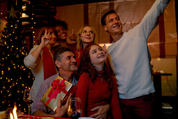 Caucasian family enjoy and do selfie together during Christmas holiday with they celebrate at home at night time.