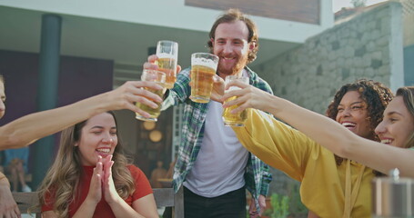 Diverse group of friends toasting celebrating life. people toast during barbecue garden party in the sunlight outdoors