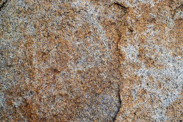 Raw gray granite rock texture background. Fragment of natural stone wall