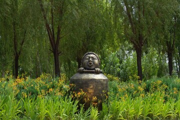 Mudanjiang, Heilongjiang, China - June 21 2021: An architecture statue a kid hide in a barrel