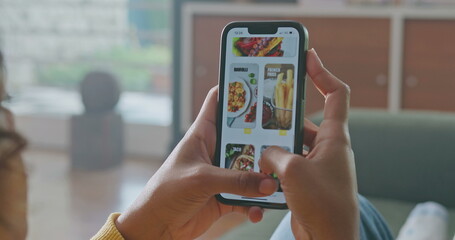 Closeup female hands holding cellphone browsing food online menu on phone. Person searching for food order on application device