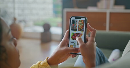 Closeup female hands holding cellphone browsing food online menu on phone. Person searching for...