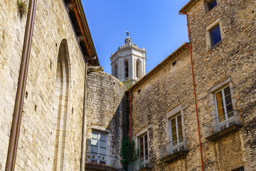Obraz premium Old stone houses and cathedral tower emerging above the roofs, Gerona, Spain.
