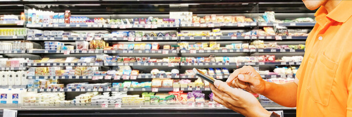 Behind the scenes work of a smartphone food delivery man picks up orders from a customer ordering food in a supermarket by choosing quality products in an online supermarket.