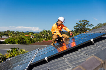 Solar panel technician with drill installing solar panels
