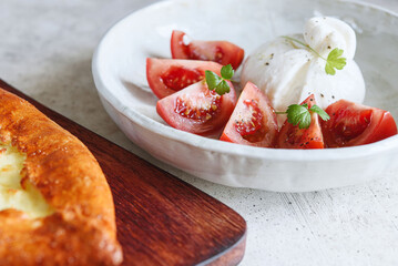 Italian burrata cheese with tomatoes and olive oil. Light summer dinner or snack. Healthy eating. Vegetarian food. Selective focus