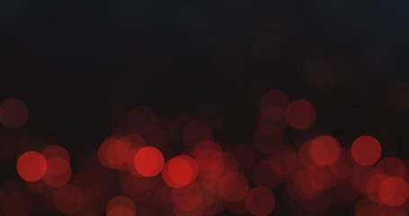Defocused circles. Bokeh glow background. Night city light. Blur red color round flecks on dark black abstract empty space wallpaper.