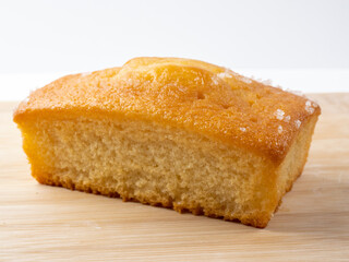 Lemon drizzle  loaf tin cake isolated on a bamboo board
