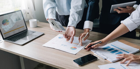 Closeup of businesspeople hands pointing a pie chart together on the paperwork