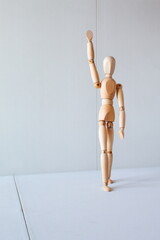 Greeting or leadership concept represented in a wooden doll