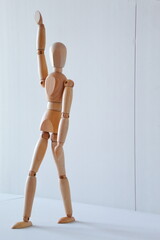 Greeting or leadership concept represented in a wooden doll