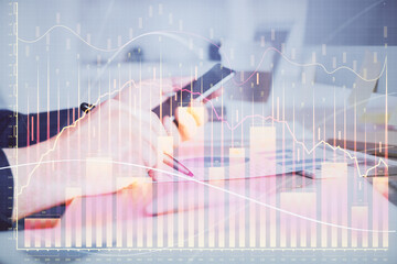 Double exposure of man's hands holding and using a phone and financial graph drawing. Analysis concept.