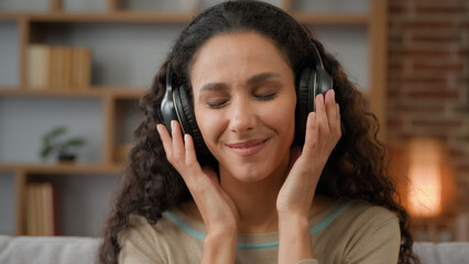Front view close up smiling Hispanic woman with smiling enjoining lady relaxing at home with closed...