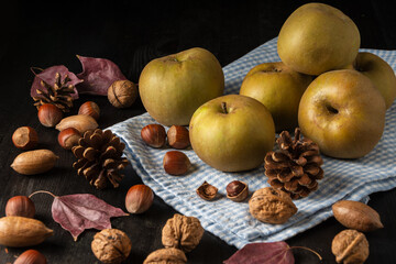 Obraz na płótnie Canvas Top view of pippin apples on blue cloth, on wooden table with dry fruits and autumn leaves, horizontal