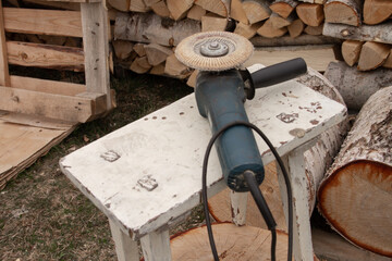 a hand tool for grinding wood lies on an old stool