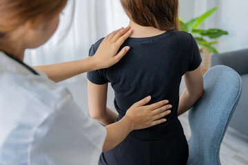 Female doctor doing physiotherapy to treat back. Female office worker back pain treatment. Doctor,...