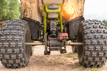 Rear view of the ATV standing on sandy ground