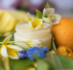 Obraz na płótnie Canvas A jar of cosmetic cream and an orange cut in half. Natural cosmetic