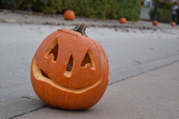 Close up of a carved pumpkin for Halloween in a residential street. Jack-O-Lantern decoration in nice neighborhood