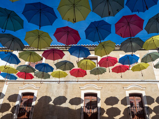 Sombras de paraguas colgados en las fachadas de Malpartida (Cáceres)