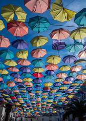 Fototapeta na wymiar Paraguas de colores colgados en las calles de Malpartida