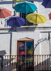 Paraguas de colores colgados en las fachadas de las casas de Malpartida