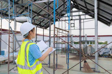 Young engineers working,Plan for  construction of a warehouse,See the construction drawings for the storage facility.