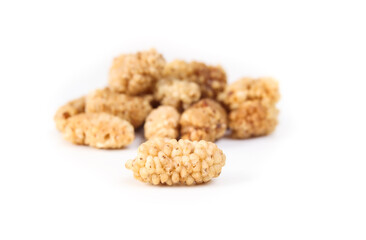 Dried mulberries in a pile, isolated. Dehydrated organic fruit used as snack, granola or in baking. Superfood. Selective focus with defocused pile of mulberries.