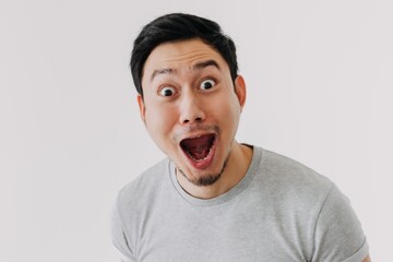 Funny shocked surprised closeup asian face man isolated on white background.